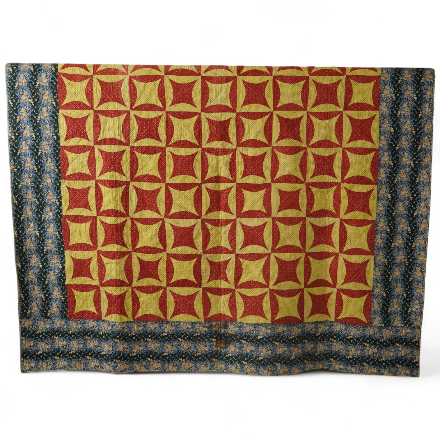 An early 1900’s American, possibly Pennsylvanian ‘robbing Peter to pay Paul’ quilt. Made with brick red and complimentary yellow tiny spot floral printed cotton. With a wide older chintz cotton border and block printed c